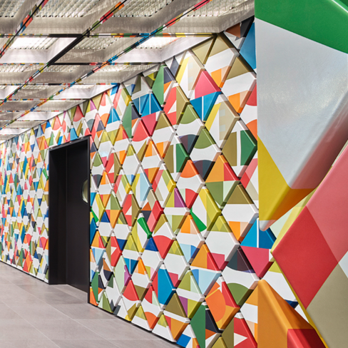 Mur avec motif géométrique coloré de triangles tridimensionnels dans un intérieur moderne